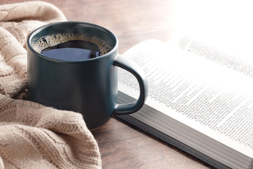 Cup of coffee with open Bible